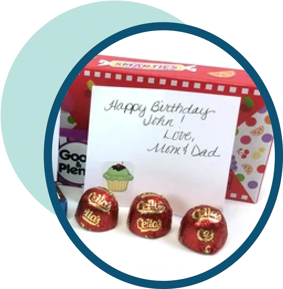 A hand-written card displayed near a box of candy and chocolate covered cherries
